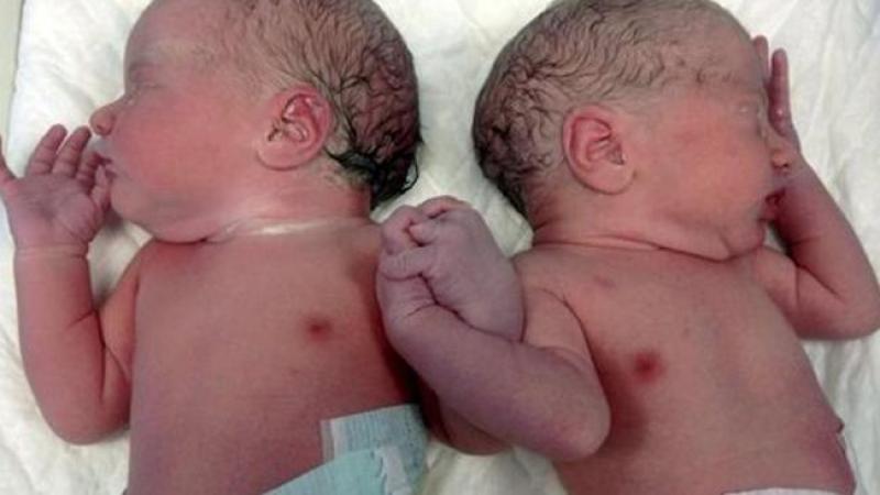 Recién nacidos se cogen de la mano.