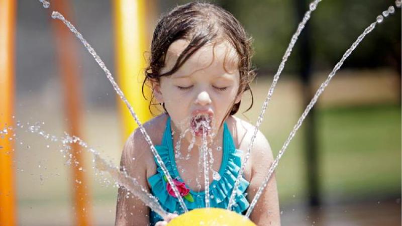 Una niña se refresca en una fuente pública en medio de una ola de calor en Oklahoma.