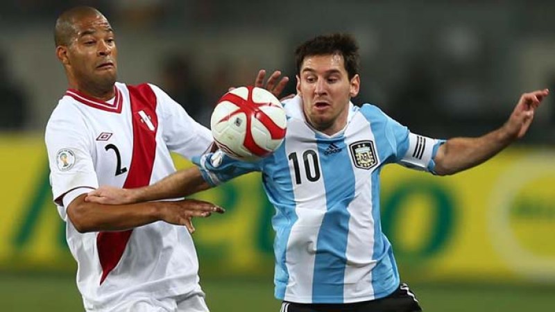Lionel Messi (d) de Argentina disputa el balón con Alberto Rodríguez de Perú.