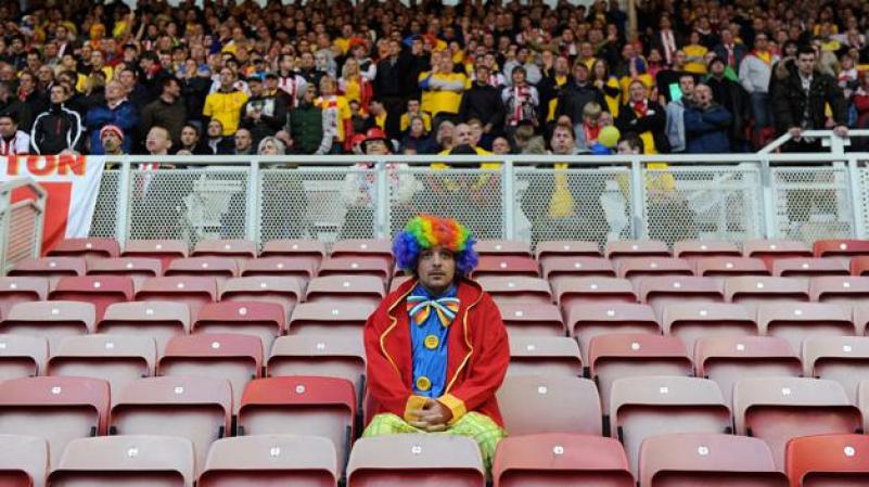 LUNES 23 DE ABRIL: Un fanático del fútbol vestido de payaso ve este sábado un partido entre los equipos ingleses de Middlesbrough y Southampton en Inglaterra.