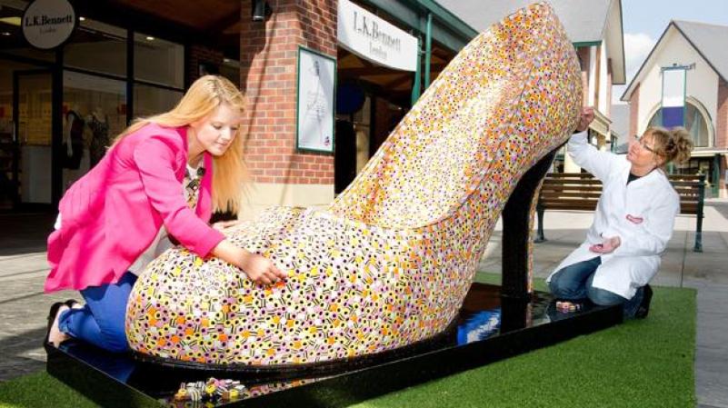 MARTES 17 DE ABRIL: Una consultora de estilo y una fabricante de dulces de la compañía Bassetts ponen los toques finales a uno de los accesorios más codiciados en estos momentos en el Reino Unido: un zapato gigante confeccionado con unos 22,000 dulces de liquorice.