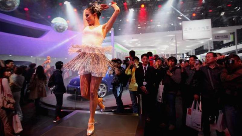 MIERCOLES 25 DE ABRIL: Una bailarina entretiene a los asistentes de la exhibición internacional de autos en Pekín, China. Más de 2,000 empresas automotrices de 14 países y regiones participan en este evento.