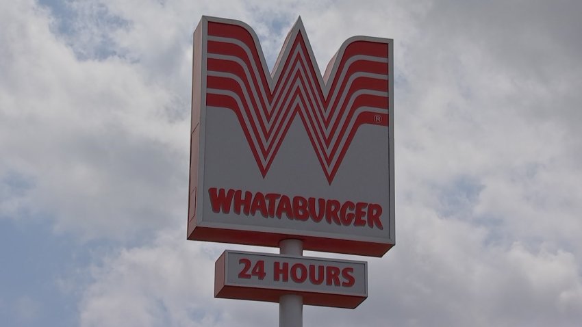 Letrero grande de Whataburger con el característico logo en forma de ‘W’ ubicado frente al restaurante de comida rápida.