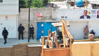 Equipo de remoción en la calle donde está la vivienda de un presunto feminicida serial en México