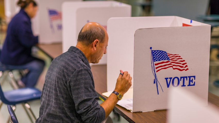 FAIRFAX COUNTY, VIRGINIA, USA – NOVEMBER 4, 2008: Voter at polls during presidential election, using paper ballots.