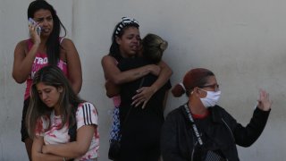 Mujeres lloran tras masacre en una favela