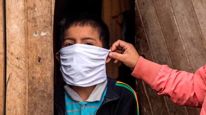 Peruvian Marlith Mori arranges her son Jeyson’s face mask at their home on the heights of the Vista Alegre shantytown of the Comas district in the outskirts of Lima, on May 21, 2020, amid the new coronavirus pandemic. – Mori lives in an area where residents’ low budgets force them to break mandatory isolation to find daily means of support. Peru crossed the 100 thousand confirmed cases and statistics stand as of May 21 on 108,769 infected, of which 43,587 have recovered and 3,148 have died since the virus was first detected in Peru on March 6. (Photo by Geraldo Caso BIZAMA / AFP) (Photo by GERALDO CASO BIZAMA/AFP via Getty Images)