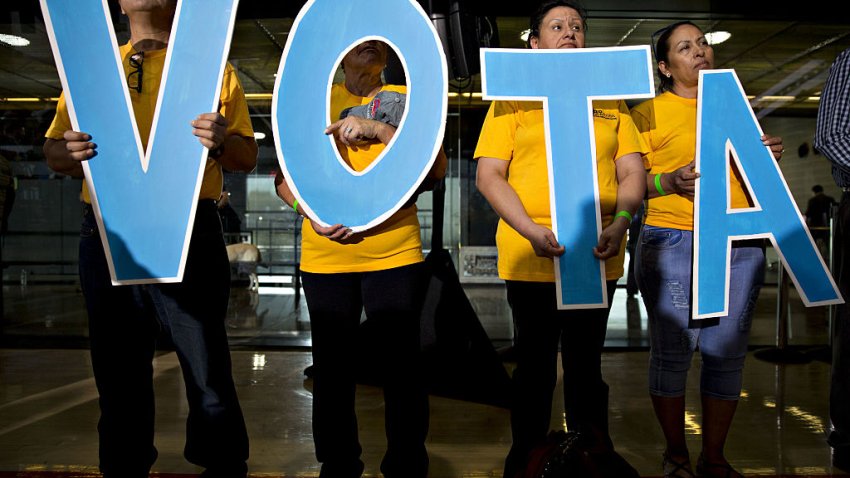 Attendees hold letters reading “Vote” in Spanish during a campaign event with Tim Kaine, 2016 Democratic vice presidential nominee, in Phoenix, Arizona, U.S., on Thursday, Nov. 3, 2016.