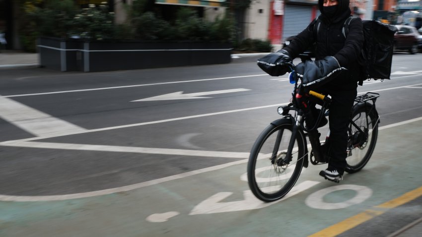 A delivery person rides an electric bicycle through the streets of Manhattan. (Photo by Spencer Platt/Getty Images)