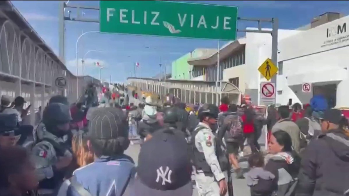 Hundreds of migrants try to force their way into the United States through a Mexican bridge