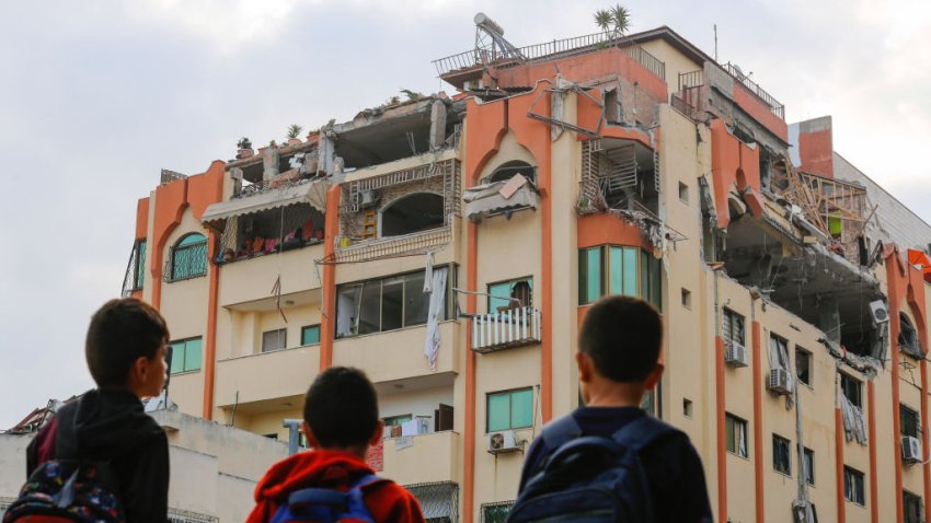 GAZA, PALESTINE – 2023/05/09: Children stand near a damaged building following Israeli airstrikes on an apartment of an Islamic Jihad commander in Gaza City. Israeli air strikes killed 13 people before dawn on May 9, 2023, in the Gaza Strip, according to the health ministry of the Hamas-controlled territory. The Israeli military announced it had carried out strikes against Palestinian “Islamic Jihad targets” in the area. The Israeli military says it has killed three senior commanders of the militant Islamic Jihad group in targeted airstrikes. Palestinian health officials said 13 people were killed in total in Tuesday’s attacks, including the commanders, their wives, several of their children and others nearby. (Photo by Ahmed Zakot/SOPA Images/LightRocket via Getty Images)