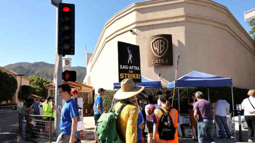 BURBANK, CALIFORNIA – JULY 14: Members of SAG-AFTRA and WGA walk the picket line at at Warner Bros studios on July 14, 2023 in Burbank, California. Members of SAG-AFTRA, Hollywood’s largest union which represents actors and other media professionals, have joined striking WGA (Writers Guild of America) workers in the first joint walkout against the studios since 1960. The strike could shut down Hollywood productions completely with writers in the third month of their strike against the Hollywood studios. (Photo by Kevin Winter/Getty Images)