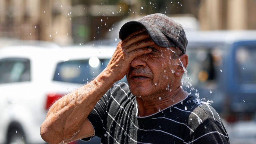 An Iraqi man splashes water on his face to cool down during a heatwave in the Shorja market in central Baghdad on August 13, 2023.