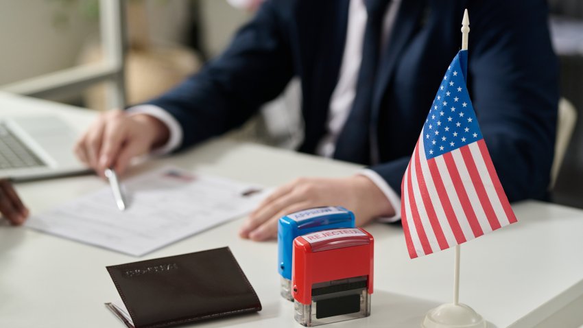 Close up of approved and rejected stamps on table in US immigration office with flag, copy space