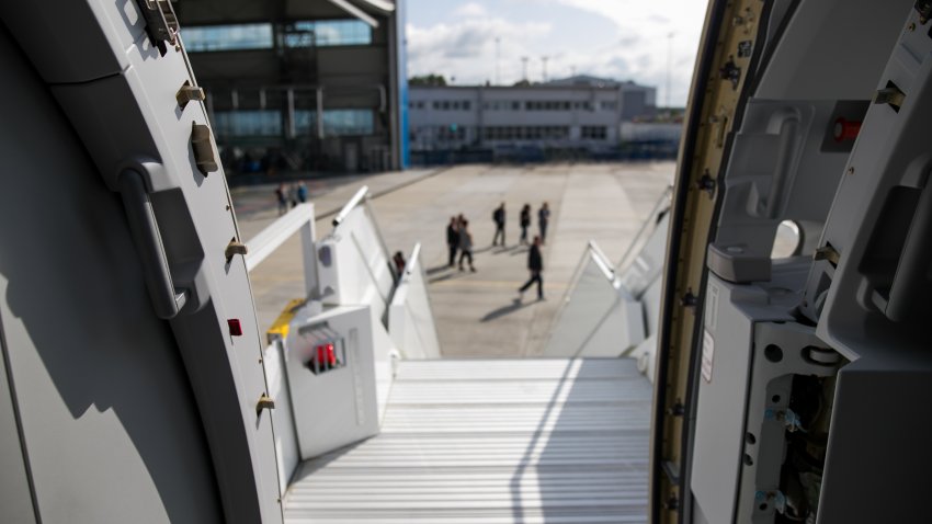 Open door to a large airliner as seen from the stairs.