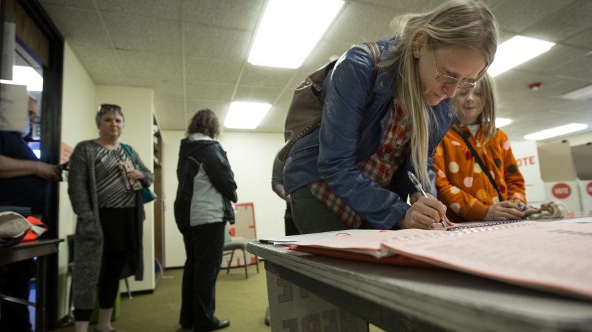 OKLAHOMA CITY, OK – MARCH 1:  Julie Dickson signs in to vote as her daughter Gwen, 9, watches at Trinity Baptist Church on Super Tuesday March 1, 2016 in Oklahoma City. Oklahoma voters head to the polls for the 2016 Presidential Primary.  (Photo by Brett Deering/Getty Images)