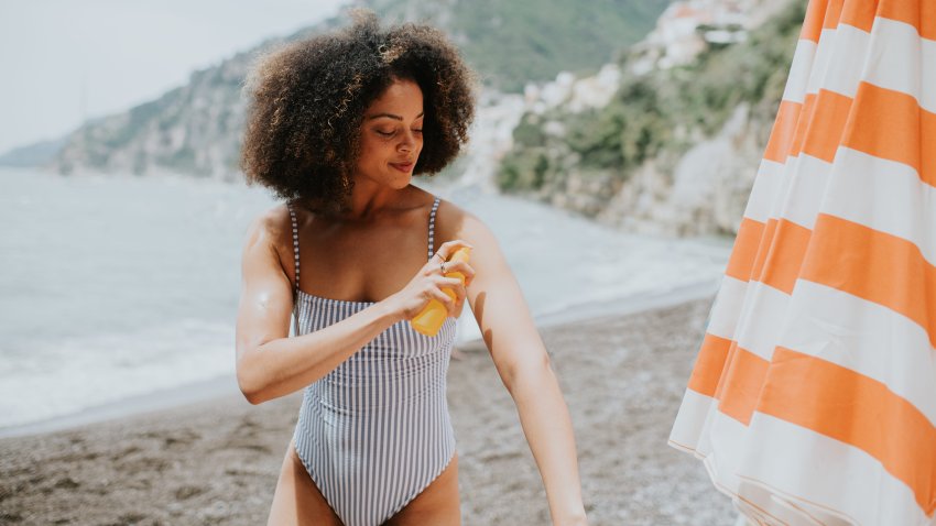 Woman applying sunscreen at the beach