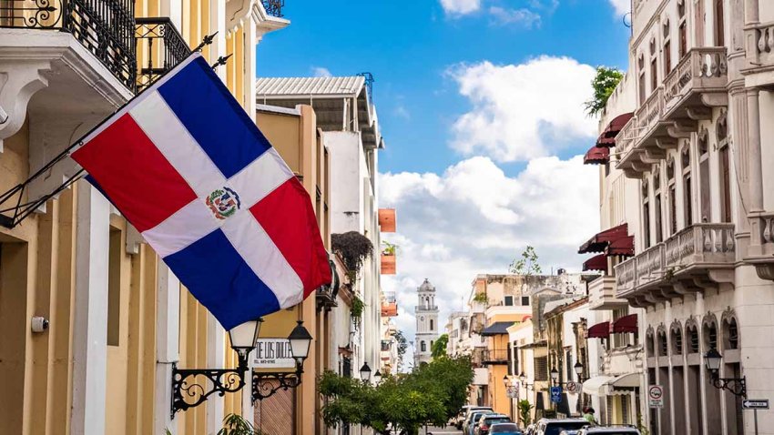 Dominican Republic, Santo Domingo – November 6, 2022: Flag of the Dominican Republic on the wall of a building in the colonial zone. Arzobispo Merino street. Popular tourist excursion.