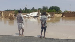 Dos personas miran sus casas dañadas por las inundaciones en Meroe, Sudán, el martes 27 de agosto de 2024.