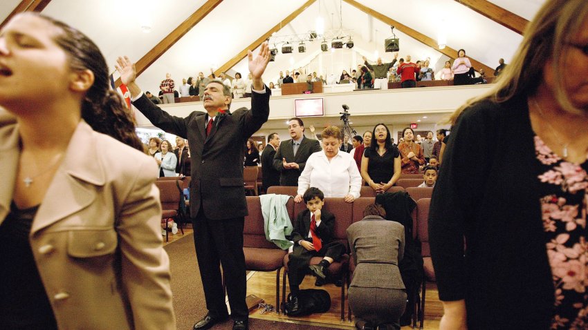 NEW YORK – MAY 1: Joe Martinez (2nd L), 61, prays with Josiah, his 5-year-old son, during a two-hour English Sunday service at a Christian Pentecostal evangelical church in the Bay Ridge section of Brooklyn May 1, 2005 in New York City. Martinez was an alcoholic and drug user before he was born again 13 years ago at the church. Joe struggled for years with substance abuse until he staggered near death into a Brooklyn neighborhood hospital from a combined alcohol and drug overdose. After recovery, one of the medical staff shocked him by saying he was surprised Joe was still alive with the amounts he had consumed. Joe had tried Alcoholics Anonymous and made other attempts to join a Pentecostal evangelical church. Both of Joe’s sisters are born again Christians. He finally found a church with a Puerto Rican pastor that readily accepted him 13 years ago. He’s now the maintenance supervisor for the Bay Ridge Christian Church. Joe remarried another born-again Christian, Jeanette, 41, and now they have a 5-year-old son. Joe spends nearly 12 hours a day at the BRCC before driving home to Staten Island. The spontaneity and fervor in the Bay Ridge church draws Latino Pentecostal congregants who embrace a style of worship far different from the repetitive, ritualistic mass they left behind in Roman Catholic parishes in East Harlem, Puerto Rico, Mexico and El Salvador. In New York City there are over 2000 Pentecostal churches whose congregations are predominantly Latino. The conversions of large numbers from Catholicism started 15 years ago and have been causing concern among Catholic leaders, who have relied on Latino immigrants to replenish the declining numbers of parishioners in the US (Photo by Robert Nickelsberg/Getty Images)