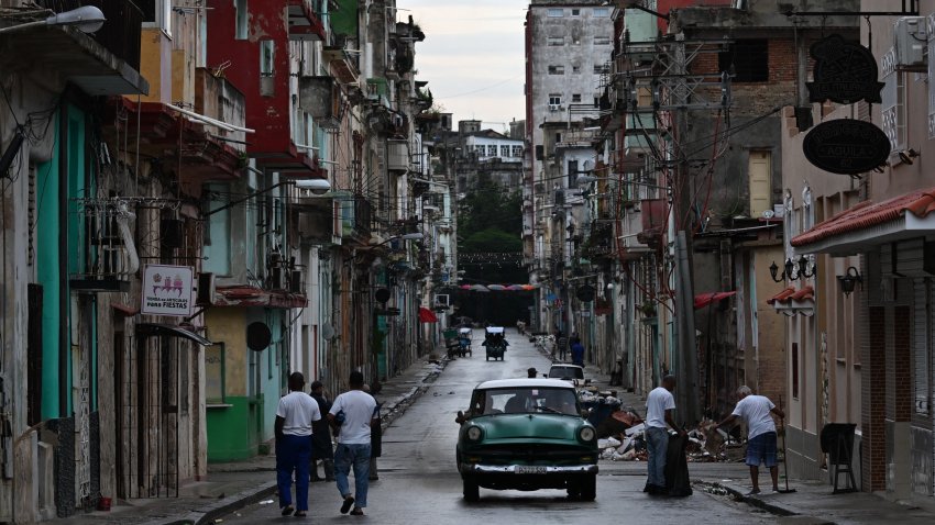 People walk along a street during the fourth day of a massive power outage in Havana on October 21, 2024. Electricity has been restored to half of Havana, the Cuban capital’s power company reported Monday, four days after the start of a nationwide power blackout that the authorities have struggled to fix. (Photo by YAMIL LAGE / AFP) (Photo by YAMIL LAGE/AFP via Getty Images)