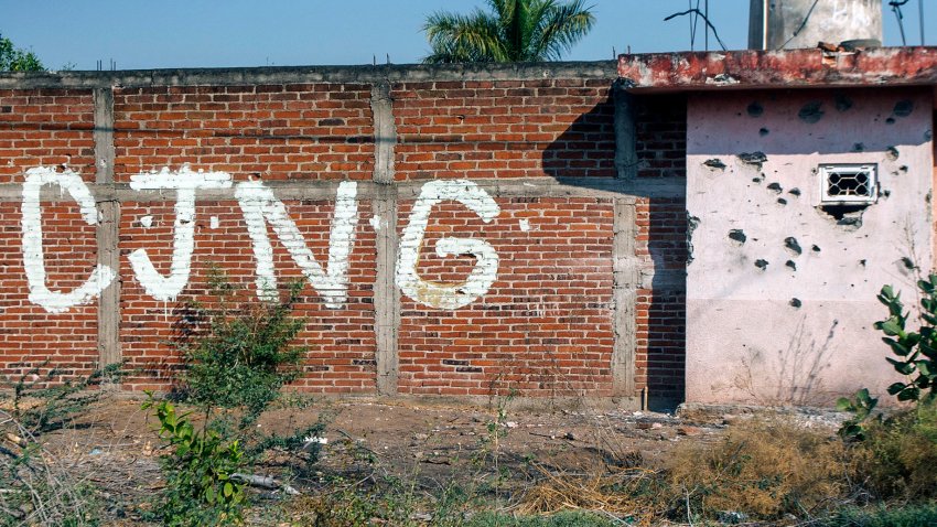 View of a bullet-riddled wall bearing the initials of the criminal group Cartel Jalisco Nueva Generacion (CJNG) at the entrance of the community of Aguililla, state of Michoacan, Mexico, on April 23, 2021. – The municipality of Aguililla is being threatened due to the confrontation of organized crime groups called the Jalisco Nueva Generacion Cartel (CJNG) and the Michoacan Family (now called Viagras). (Photo by ENRIQUE CASTRO / AFP) (Photo by ENRIQUE CASTRO/AFP via Getty Images)