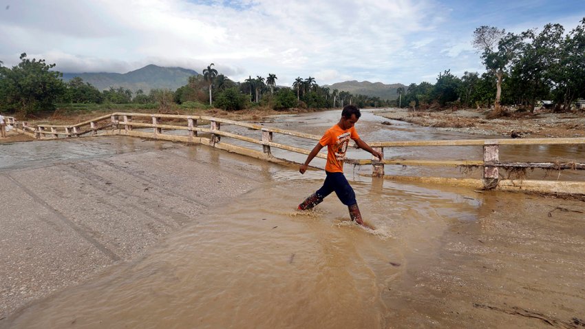 Fotografía de archivo del 29 de octubre de 2024 en donde un joven camina por una calle inundada en la región de San Antonio del Sur tras el paso de la tormenta tropical Óscar, en la provincia de Guantánamo, a más de 900 km de La Habana (Cuba). EFE/ Ernesto Mastrascusa