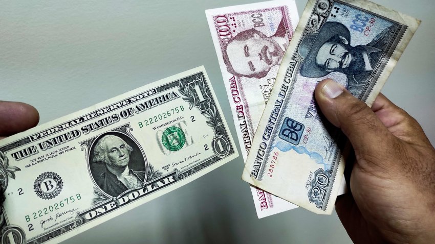 A man shows a dollar and Cuban pesos in Havana, on August 4, 2022. The Central Bank of Cuba (BCC) reported that as of Thursday banks and exchange houses will begin to buy dollars at a price of 120 Cuban pesos per bill, a rate similar to that of the black market, a mechanism aimed at capturing foreign currency. (Photo by YAMIL LAGE / AFP) (Photo by YAMIL LAGE/AFP via Getty Images)