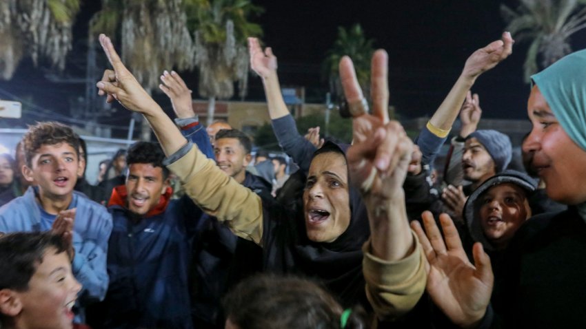 People celebrate along a street at Deir el-Balah in the central Gaza Strip, on January 15, 2025, amid the ongoing war in the Palestinian territory between Israel and Hamas. Crowds of Gazans chanted and embraced on January 15 as news spread that a ceasefire and hostage release deal had been reached between Israel and Hamas aimed at ending more than 15 months of war in the Palestinian territory. (Photo by Youssef Alzanoun / Middle East Images / Middle East Images via AFP) (Photo by YOUSSEF ALZANOUN/Middle East Images/AFP via Getty Images)