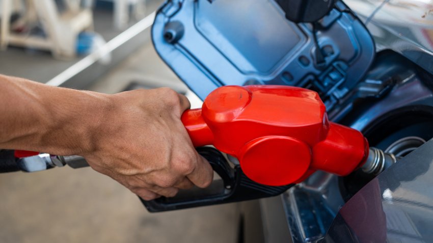 Refueling the car at a gas station fuel pump. Man driver hand refilling and pumping gasoline oil the car with fuel at the refuel station. Car refueling on petrol station. Fuel pump at the station