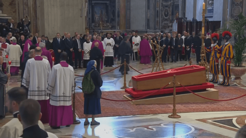 Nun stands in front of Pope's coffin