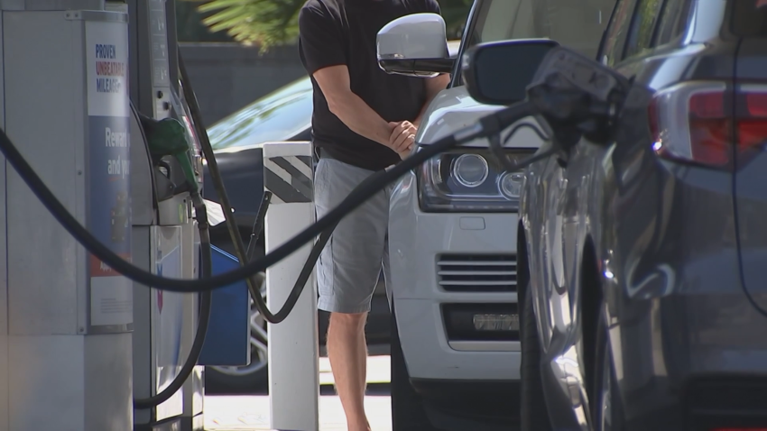 Men fill up their cars with gas at station