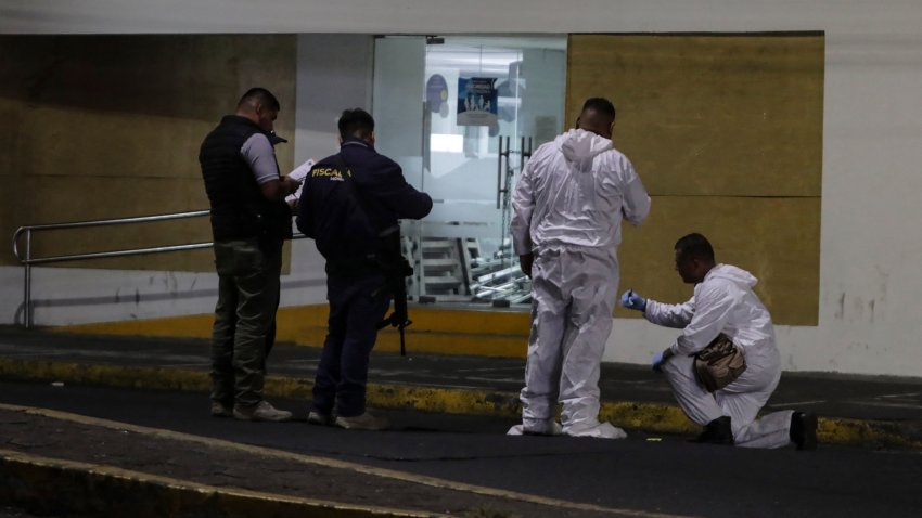 Forensic personnel and investigators from the prosecutor’s office are guarded by police while carrying out investigations in a typical Mexican food restaurant where Guillermo Torres, municipal president of Churumuco, municipality of Tierra Caliente in Morelia, Michoacan state, Mexico, was murdered on March 30, 2024. (Photo by Enrique Castro / AFP) (Photo by ENRIQUE CASTRO/AFP via Getty Images)