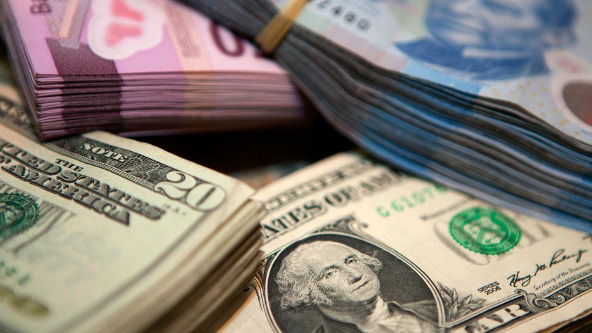 Stacks of Mexican pesos and U.S. dollar bills are arranged for a photograph inside a currency exchange in Mexico City, Mexico, on Tuesday April 9, 2013. Mexico’s peso rose to the strongest since August 2011 after a report showed faster-than-forecast inflation last month, damping speculation that policy makers will cut interest rates to slow the currency’s advance. Photographer: Susana Gonzalez/Bloomberg via Getty Images