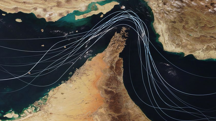 Satellite view of the Strait of Hormuz with white graphic lines representing global shipping lanes and maritime traffic between the Persian Gulf and Gulf of Oman. Strategic oil transport concept