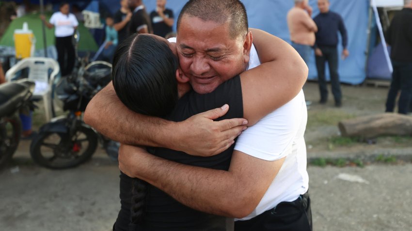 AME9178. GUATIRE (VENEZUELA), 14/08/2026.- Arturo Sairias abraza a un familiar tras ser excarcelado del centro penitenciario Rodeo 1 este viernes, en Guatire (Venezuela). Al menos 40 presos políticos fueron excarcelados, informó la ONG Foro Penal, líder en la defensa legal de estos detenidos, un hecho que se da dos días después de haber culminado la primera ronda de negociaciones entre el chavismo y un sector de la oposición liderado por la exdiputada Dinorah Figuera. EFE/ Ronald Peña R